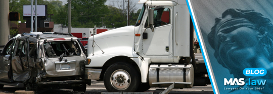 A white semi-truck and a gray car involved in a rear-end collision on the road, illustrating the impact of brake-checking accidents.