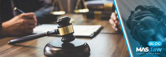 An attorney at a desk writing a demand letter | MAS Law