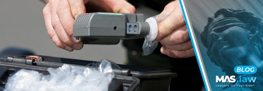 Police man changing out a breathalyzer | MAS Law
