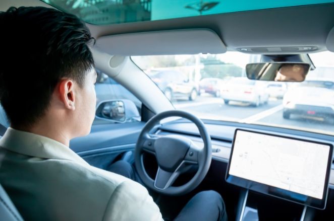 Man in the drivers seat of a self-driving car | MAS Law