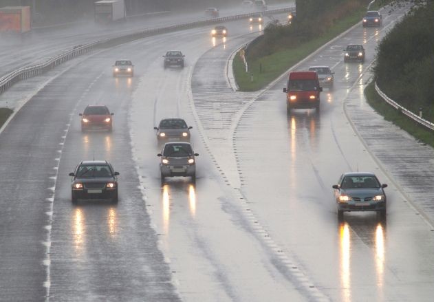 Cars driving on the highway in the rain.