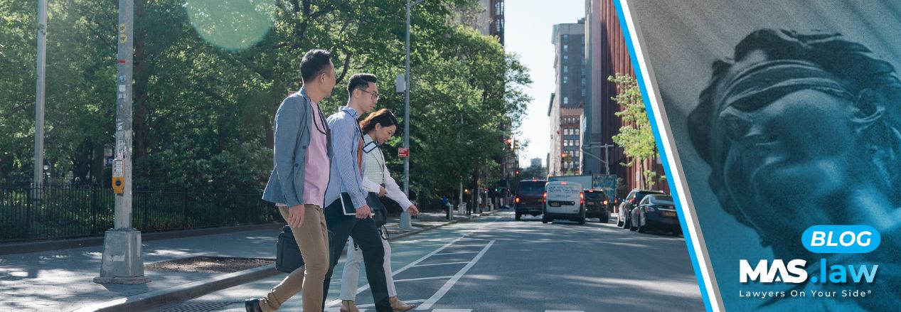 Three pedestrians crossing the road.