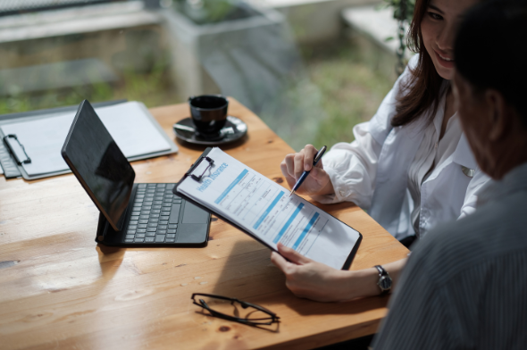 Woman explaining an insurance policy to a man | MAS Law