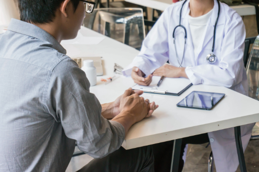 Man speaking to a Doctor at a table | MAS Law