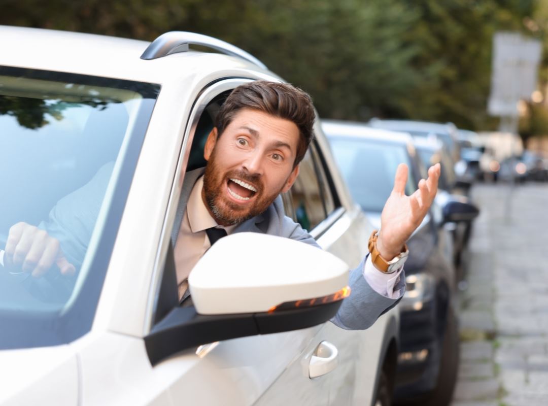 Man frustrated that he is stuck in traffic.